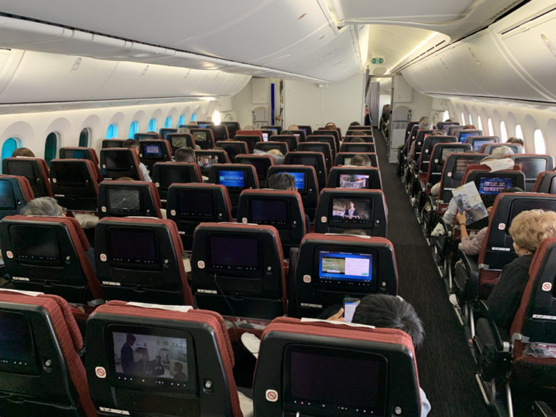 a plane with rows of seats and monitors