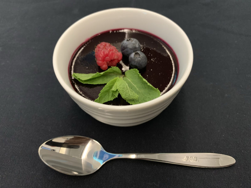 a bowl of food with berries and a spoon