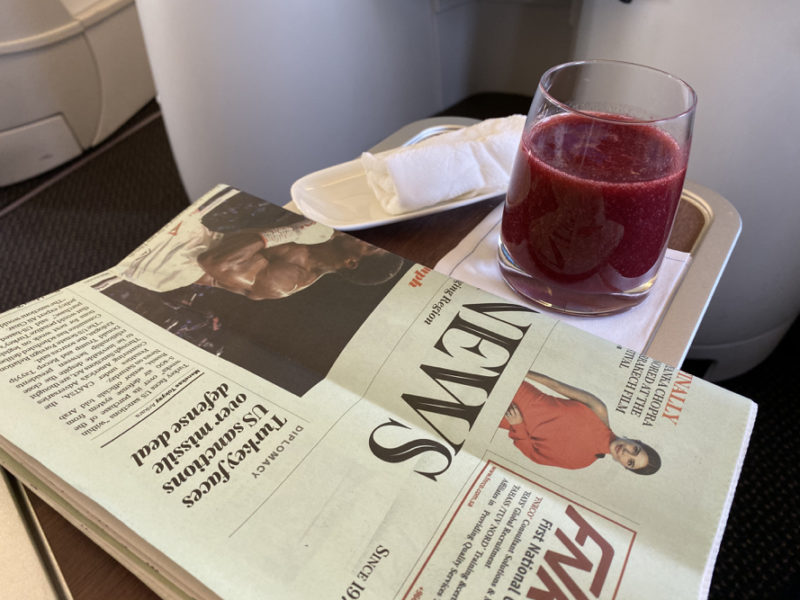 a newspaper and a drink on a tray