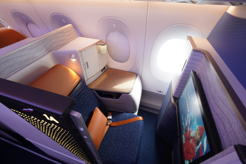 a seat and a tv in the middle of an airplane