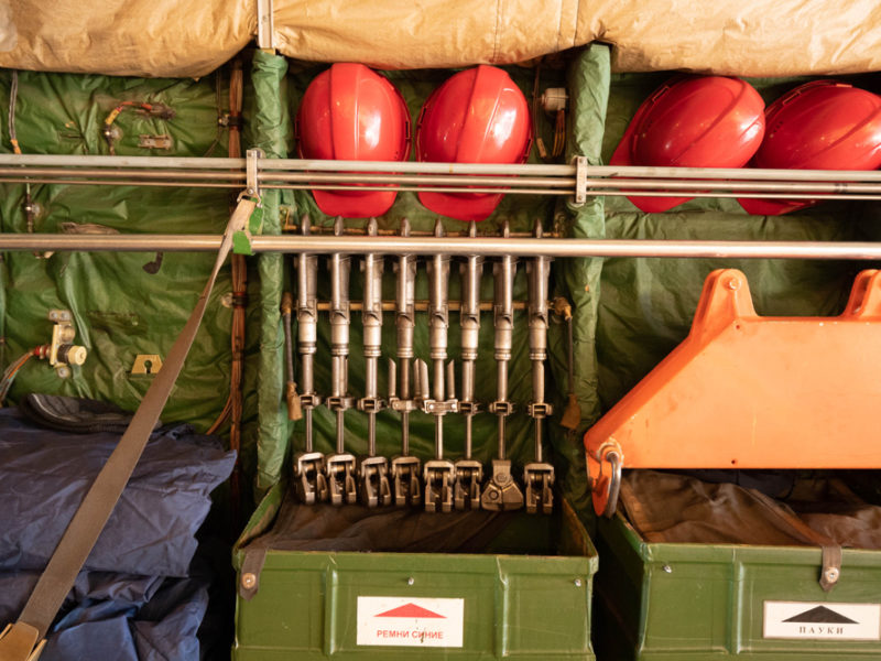 a green box with metal pipes and red helmets