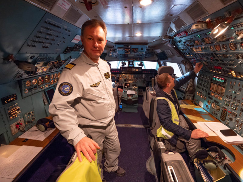 a man in a white uniform in a cockpit of a plane