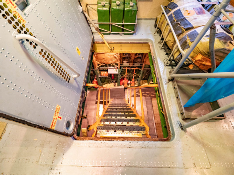 a staircase in a room with metal ladders and bags