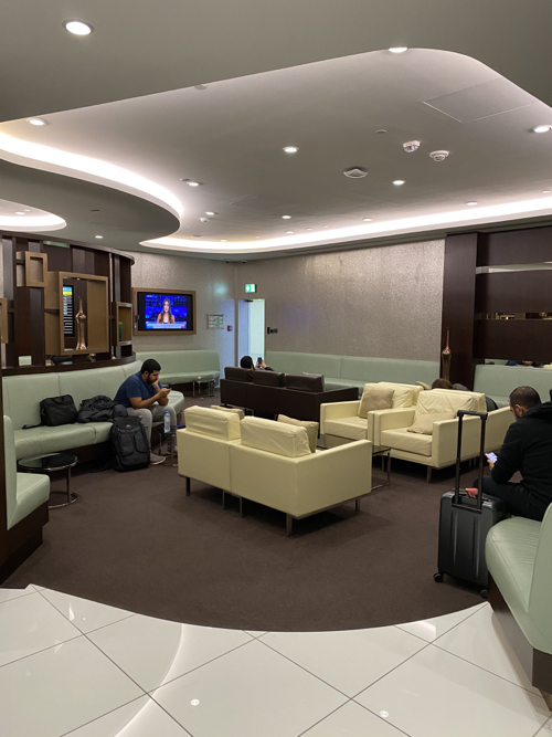 a group of people sitting in a room with chairs and a suitcase