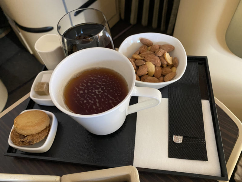 a tray with a cup of tea and nuts