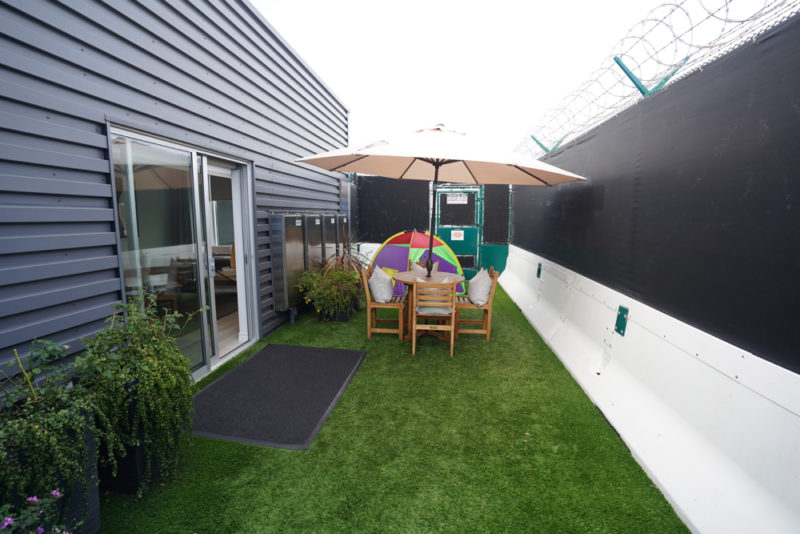 a patio area with a table and chairs and umbrella