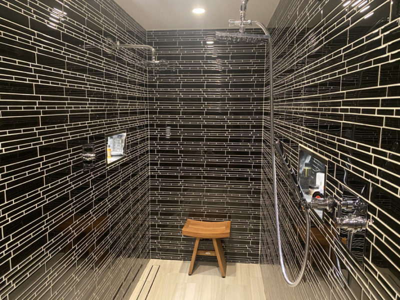 a shower with a stool in the back