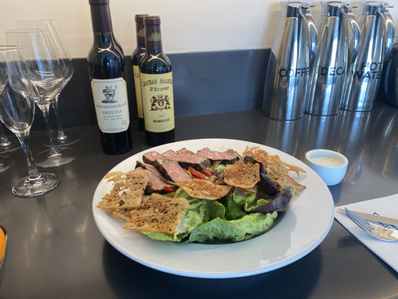 a plate of salad and wine bottles