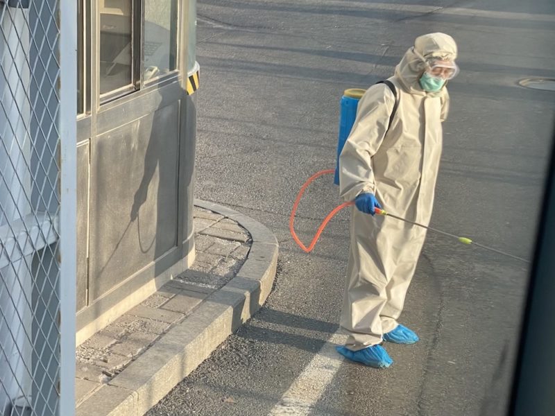 a person in a hazmat suit spraying a spray gun