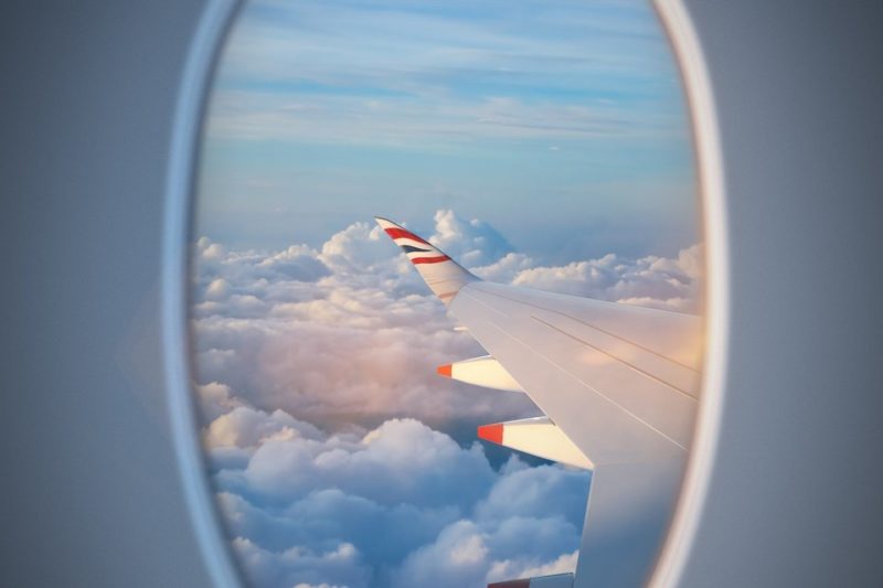 an airplane wing with clouds in the background
