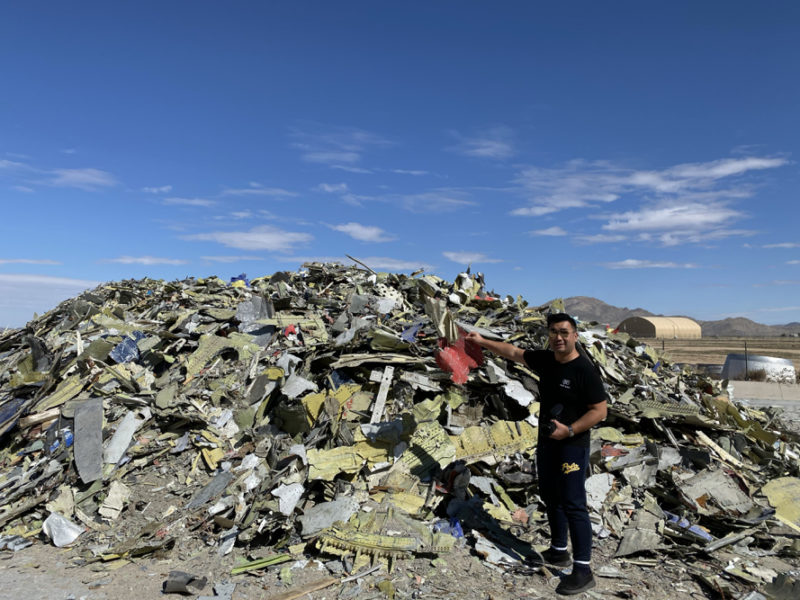a man standing in front of a pile of debris