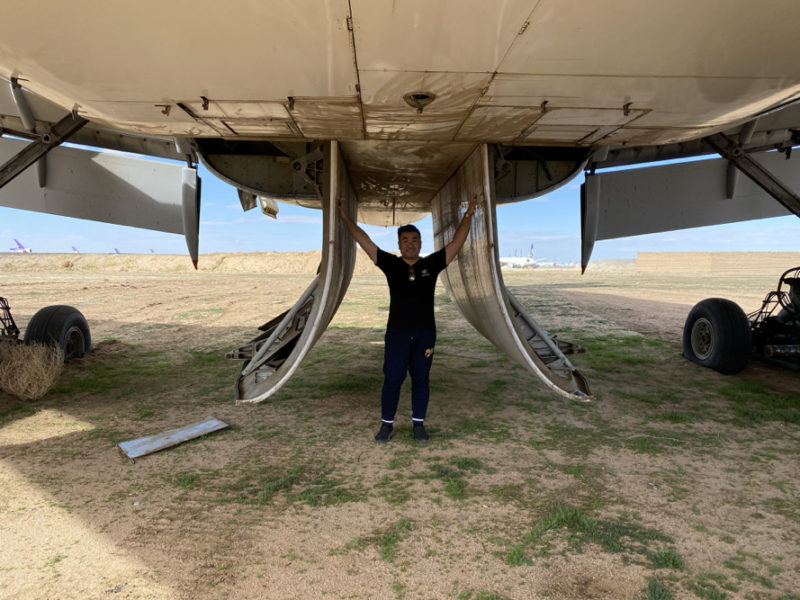a man standing under an airplane