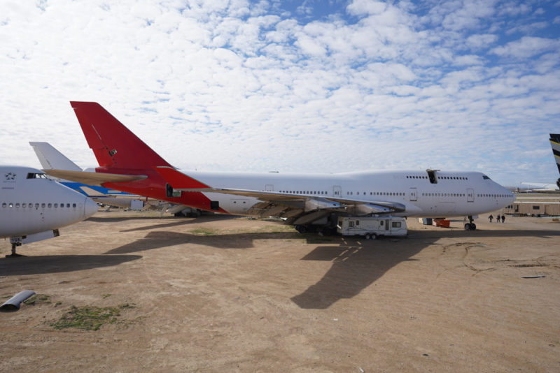 a large airplane parked on a dirt field