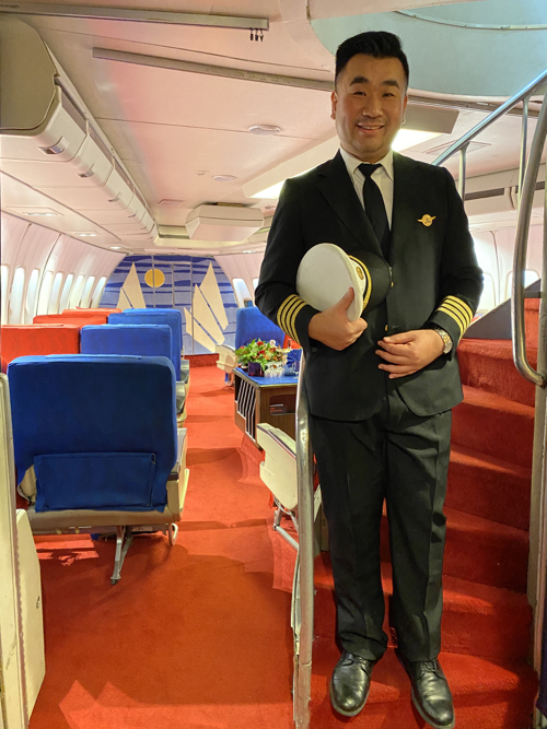a man in a uniform standing on a plane
