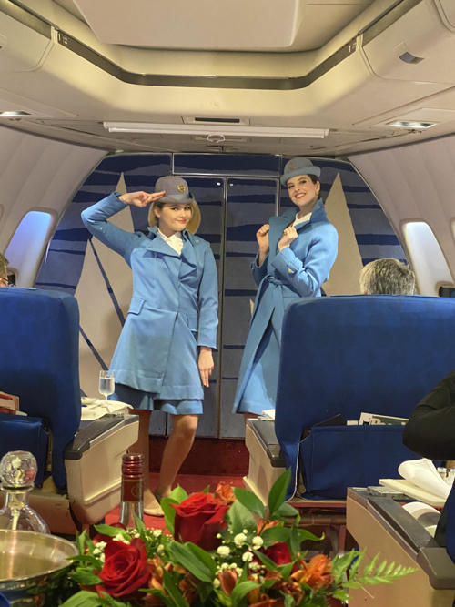 two women in blue uniforms in an airplane