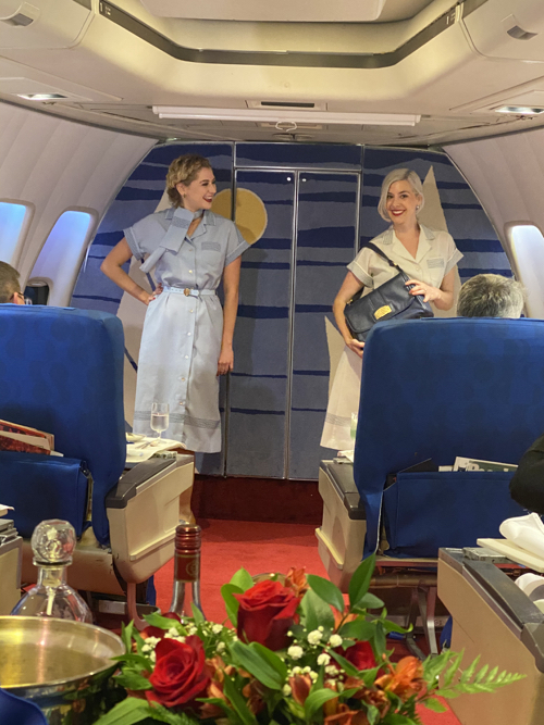 two women standing in an airplane