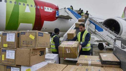a group of people loading boxes into an airplane