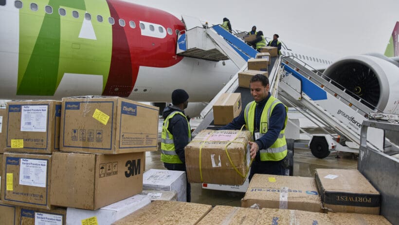 a group of people loading boxes into an airplane