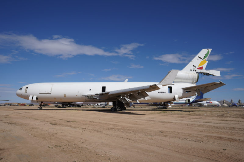 a white airplane on a dirt field