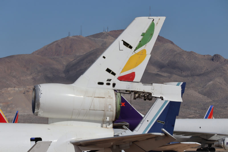 the tail of a plane with mountains in the background