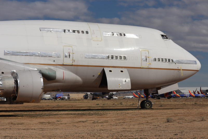 a large white airplane on a dirt field