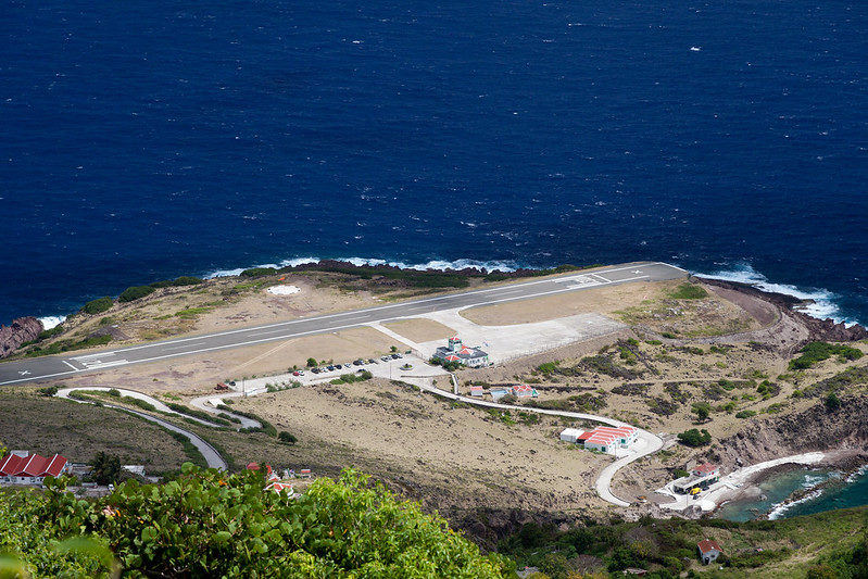 an aerial view of a runway next to a body of water