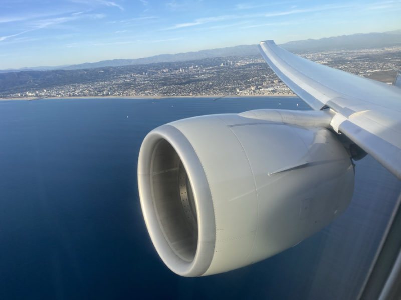 an airplane wing with a city in the background