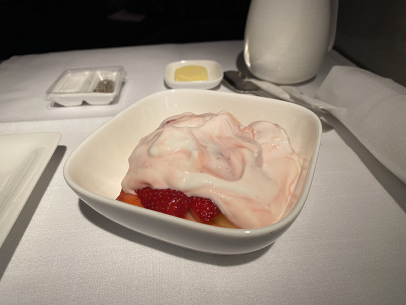 a bowl of dessert with strawberries and whipped cream