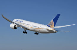 a white airplane with blue and orange tail and landing gear