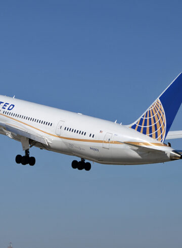 a white airplane with blue and orange tail and landing gear