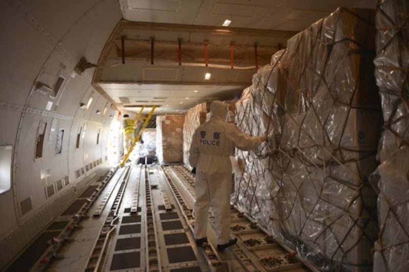 a man in hazmat suit standing in a cargo plane