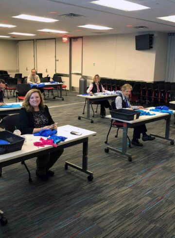 a group of people sitting at desks in a room