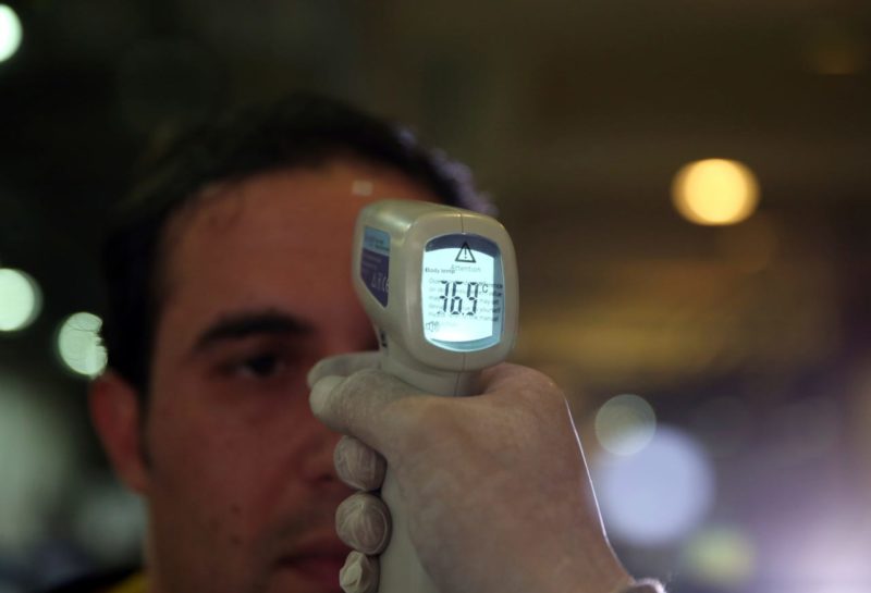 a person holding a infrared thermometer