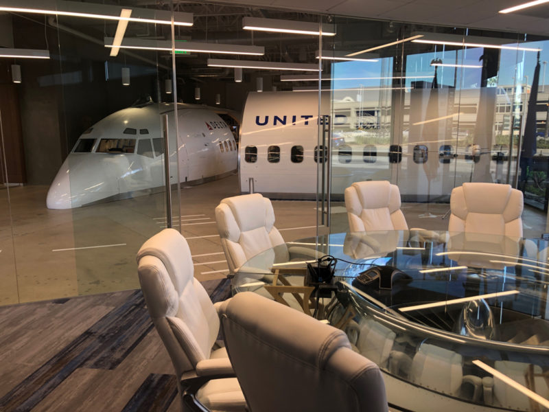 a glass table with chairs around it and a plane behind it