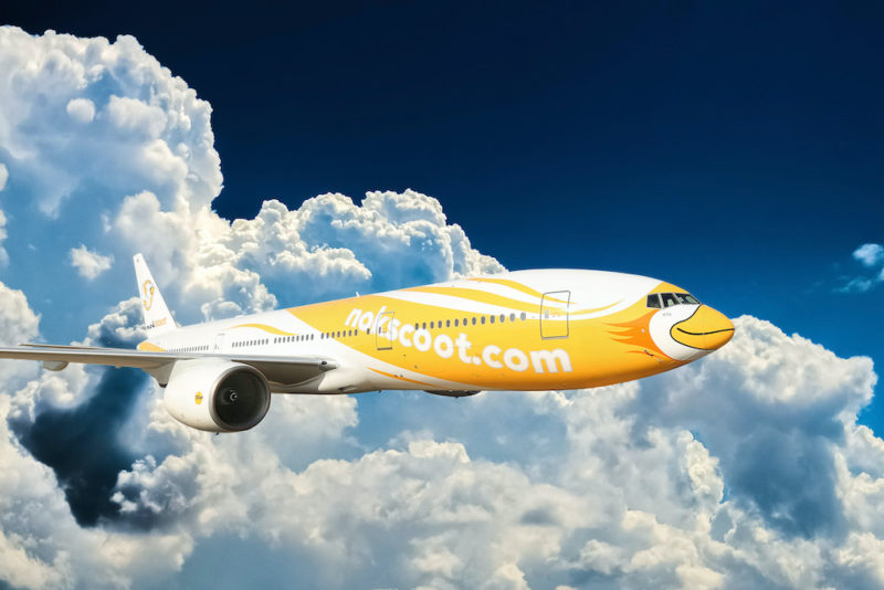 a yellow and white airplane flying in the sky