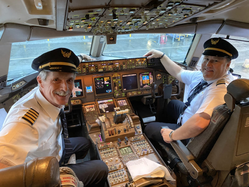 two men in uniform sitting in a cockpit of an airplane
