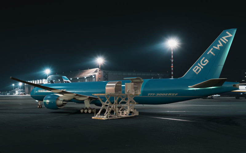 a blue airplane on a tarmac at night