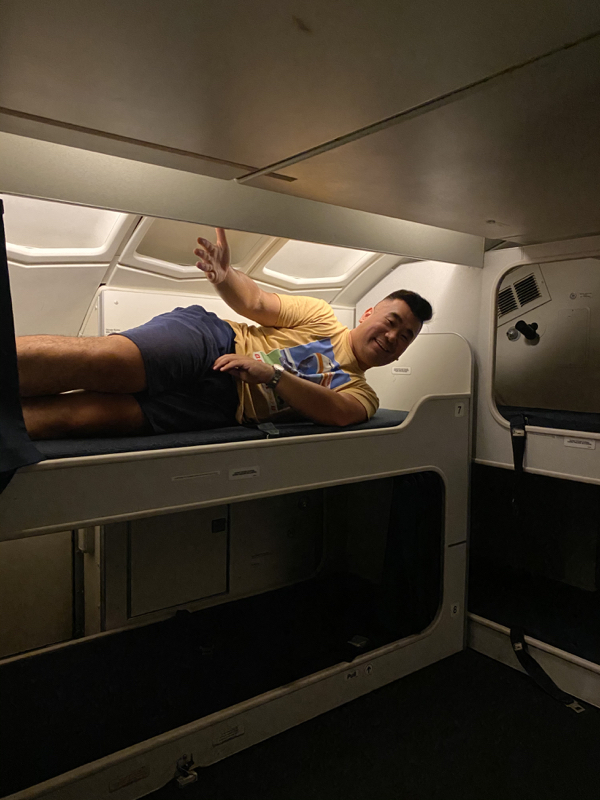 a man lying on a bed in a plane