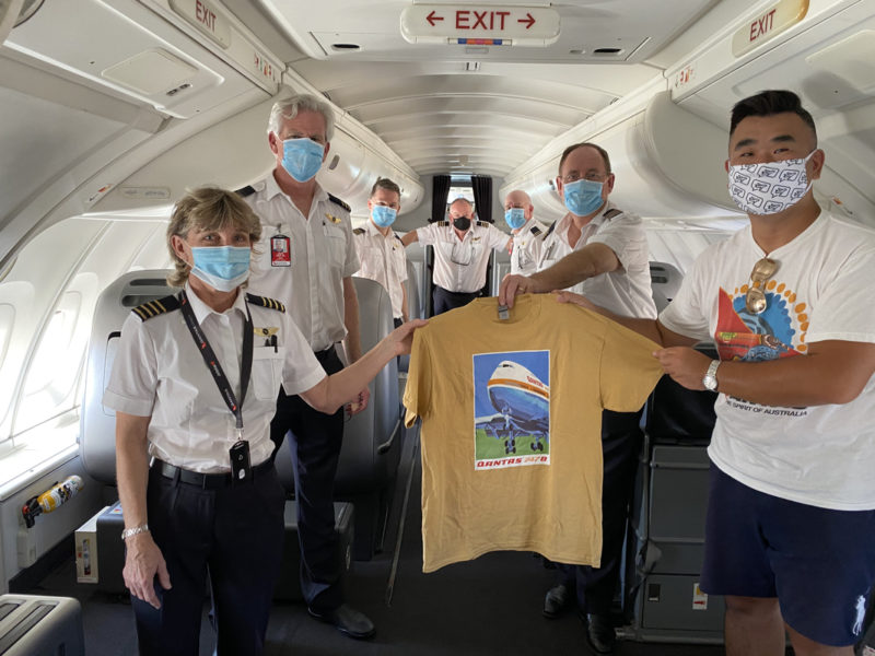 a group of people wearing face masks holding a shirt