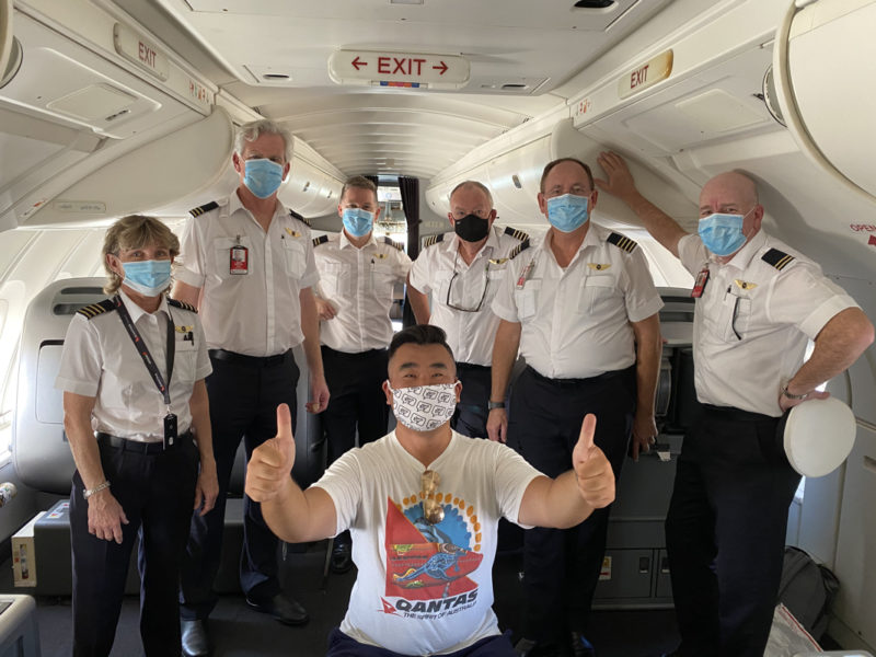 a group of people wearing face masks and standing in a plane