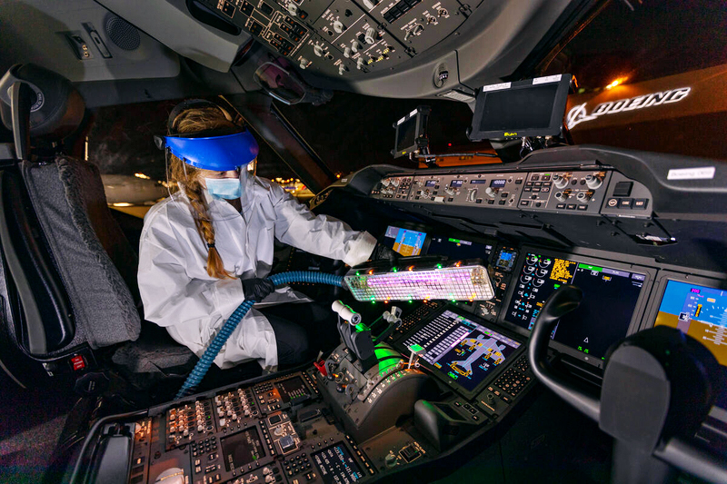 a person in a white suit and goggles in a cockpit