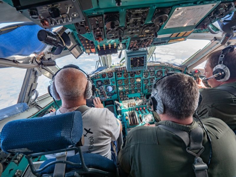 a group of men in a cockpit of a plane