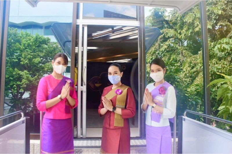 a group of women wearing face masks and standing in front of a glass door