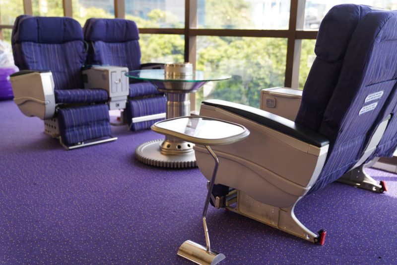 a room with purple carpet and chairs