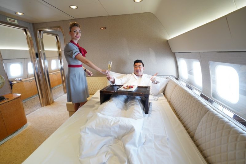 a man in a bed with a tray of food and a woman in flight
