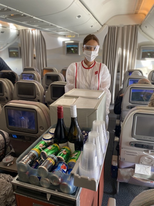 a person wearing a mask and a face mask standing in an airplane