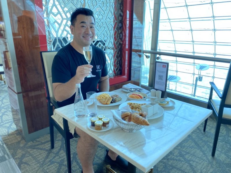 a man sitting at a table with food and drinks