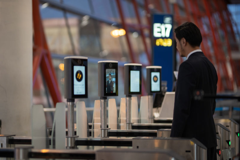a man standing in front of a row of electronic screens