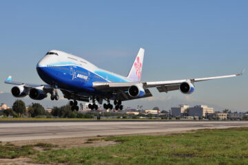 a blue and white airplane taking off