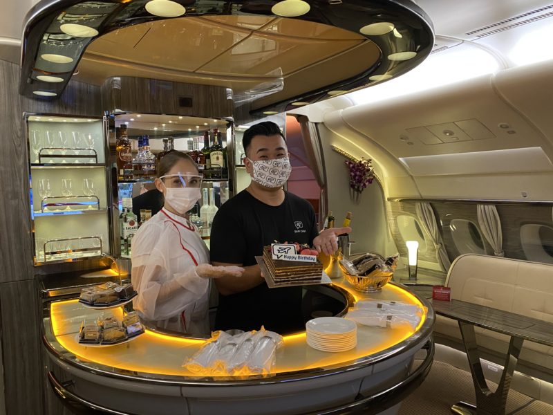 a man and woman wearing face masks behind a counter in an airplane